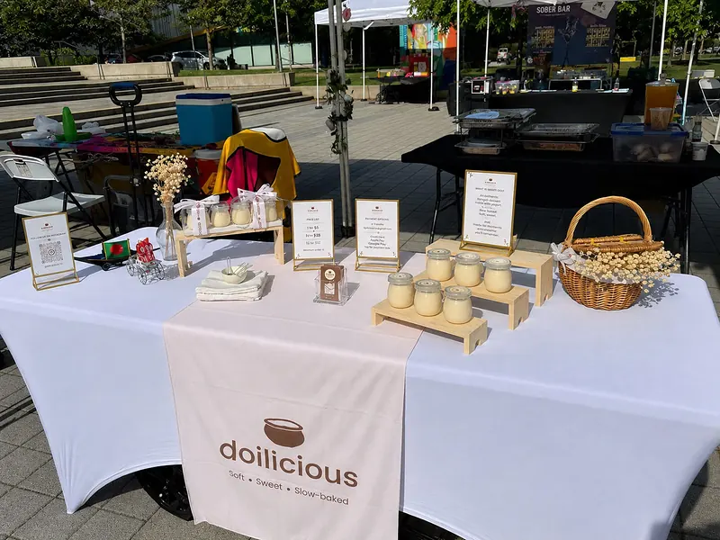 The Doilicious pop-up table at an outdoor market, with jars of doi on display